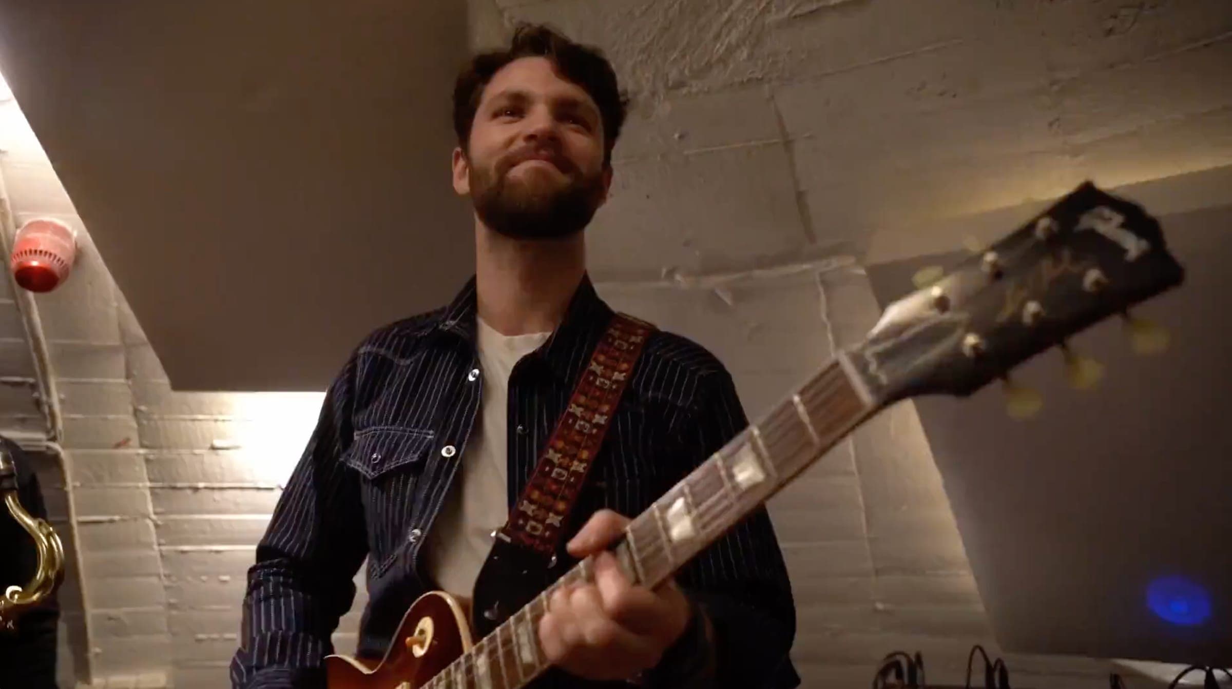 Guitarist med Les Paul smiler til publikum